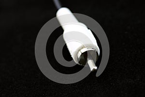 White RCA connector for audio and video closeup on black background