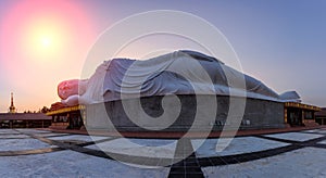 White reclining buddha during sunset , Thailand