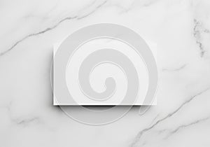 A white rectangular card is placed on a smooth, white marble