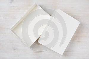 White rectangular empty open box, top view on wooden background