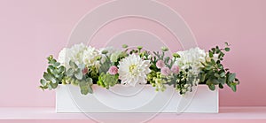 white rectangular flower box with brassica,trachelium,dianthus,eucalyptus,lisianthus,sedum,dahlia,white and pink scale,on a pink