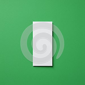 White rectangular object placed vertically on a bright green background. The object