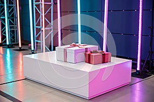 White rectangular podium with satin ribbon and gift boxes on two-tone background, neon
