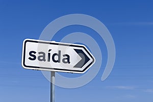 A white rectangular road sign in Portugal with the word saÃ­da, meaning exit.