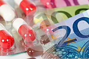 White red antibiotic capsules with euro banknotes