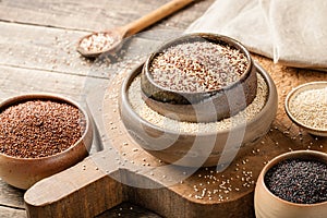 White, red, black and mixed quinoa on wooden table