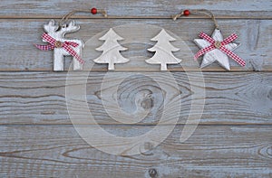 White red christmas decoration as christmas tree, reindeer and star on a old grey wooden planks background with empty copy space