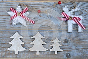 White red christmas decoration as christmas tree, reindeer and star on a old grey wooden planks background with empty copy space