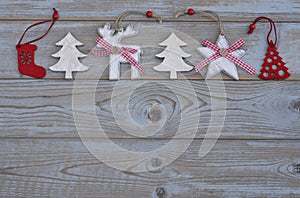 White red christmas decoration as christmas tree, reindeer and star on a old grey wooden planks background with empty copy space