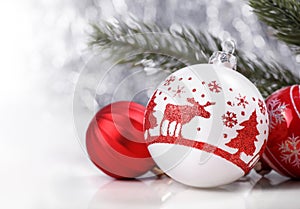 White and Red Christmas ornaments and fir tree branch on glitter bokeh background with space for text. Xmas and Happy New Year