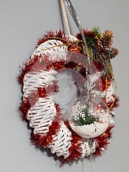 White and red christmas wreath on the light-gray wall