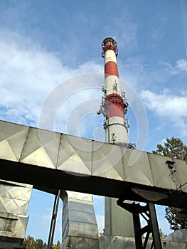 White and red concrete chimney and part of dedusting system photo