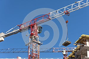 White and red construction crane on the residential building