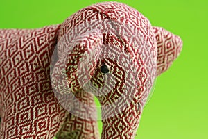 White and red elephant-shaped rag doll on a green background