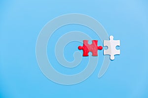 White and red jigsaw puzzle on a blue background. Copy space for text, top view, close up