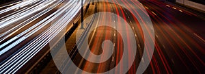 White and red lights of a car in motion at long exposure on a night highway.