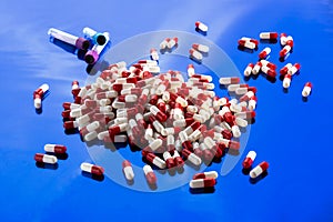 white and red medical capsules on a blue background.