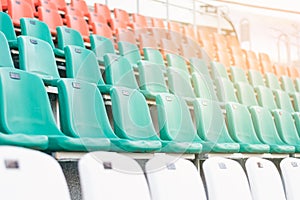 White, red and mint-colored plastic seats, arranged in rows in a stadium