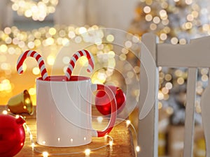 White and Red Ceramic Mug with Bright Lights Unfocused and Christmas Decorations