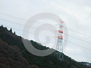 White and red painted power pole on the mountain forest