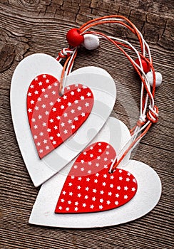 White and red sewed christmas hearts on wooden background, for greetings Valentine's day