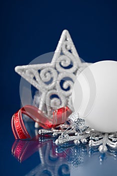 White, red and silver christmas ornaments on dark blue background