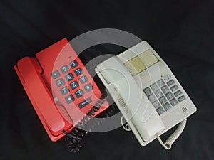 white and red telephones on a black background, close-up of the phone
