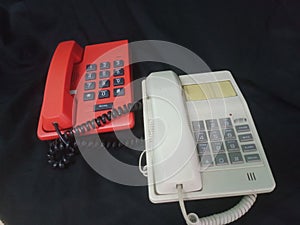 white and red telephones on a black background, close-up of the phone