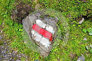 White red tourist sign painted on a rock in nature. The marks help for orientation on a hiking trail. Trailblazing, waymarking.