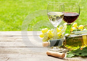 White and red wine glasses, wine bottle and white grape