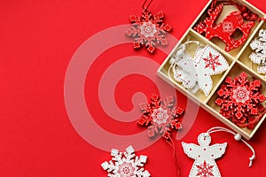 White and red wooden Christmas tree decorations on a red background with place for text