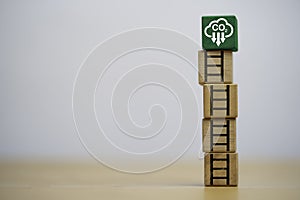 White reduction carbon emission symbol on the top of wooden block cube with staircase for carbon footprint and carbon credit to