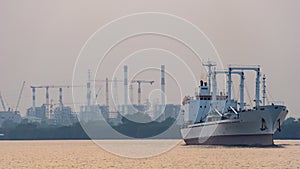 White reefer ship or refrigerated cargo ship sails in Chao Phraya river in the evening