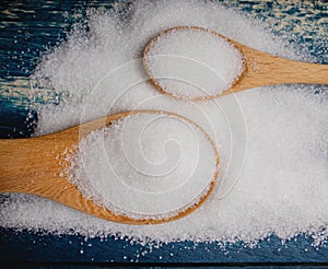 White Refined Sugar in Spoon lay on Table. Top View, Close up shot. Sweet Tasting but Unhealthy