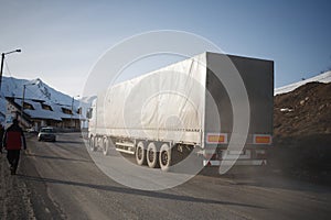 White refrigerated truck on winter road on background of the mountains