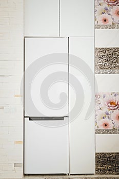 White refrigerator built into the kitchen unit. Modern kitchen concept