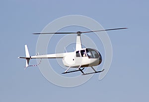 White rescue helicopter moving in blue sky