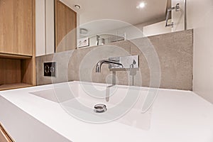 A white resin sink with a modern chrome faucet