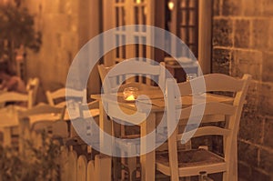 White restaurant table for two with candle outside on terrace