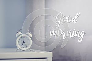 White retro alarm clock in the bedroom. Good morning card