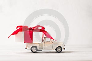 White retro toy car delivering gift box for Valentine`s day