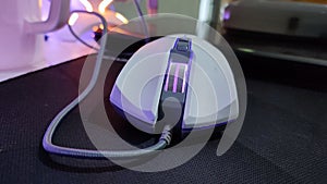 White RGB gaming mouse with gray cable in use
