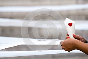 White ribbon with red nails