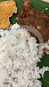 White rice with beef rendang and fried tempeh