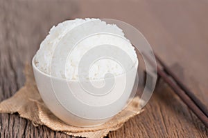 White rice in bowl with chopsticks on table.