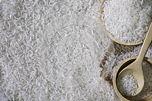 White rice seed in Brown wooden bowl with wooden spoon on Rice background. Organic, natural long rice grain, food for healthy.