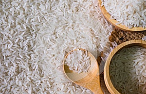 White rice seed with two brown wooden bowl and wooden spoon on rice background. Organic, natural long rice grain, food raw for hea