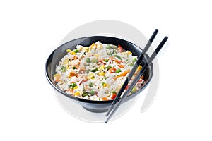 White rice with vegetables in a black bowl isolated
