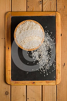 White rice in a wooden bowl on a chalkboard