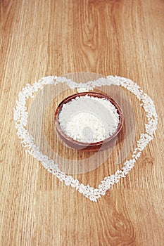 White rice in a wooden plate and rice pattern in the shape of a heart